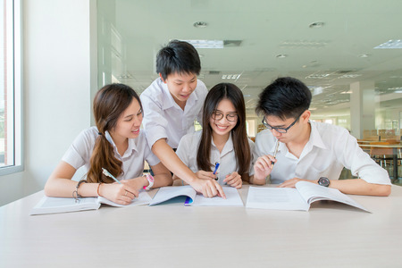 Group of asian students in uniform studying together at classroom