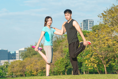 fitness, sport, training and lifestyle concept - Asian couple stretching outdoorsの写真素材
