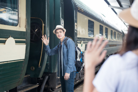 Handsome Young Asian man say goodbye to girlfriend at train station before journeyの写真素材