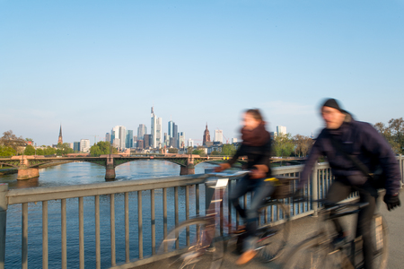 Skyline of Frankfurt, Germany - People bicycling in morning at Frankfurt am Main, Frankfurt, Germany. Frankfurt is the largest city in Germanyの写真素材