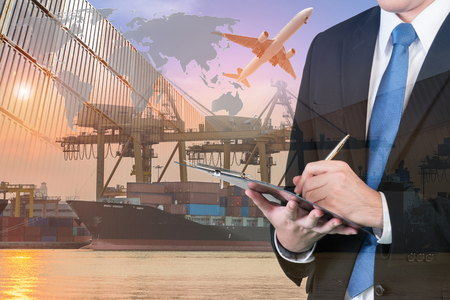 Double exposure of businessman is booking with blurred cargo , transportation port and world map. Transportation logistic business concept.