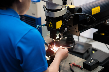Worker welding repair mold and die part by Laser welding machine in factory.の写真素材