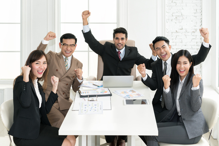 Group of muti ethnicity business people team success achievement with arm raised to celebrating good job in the office. Business people team togetherness happiness Concept.の写真素材