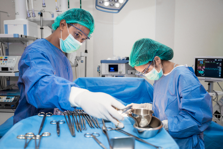 Asian doctor and an assistant in the operating room for surgical venous vascular surgery clinic in hospital.の写真素材