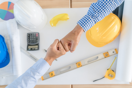 Asian team Business or engineer and architects partners giving fist bump after complete deal. Successful teamwork partnership in an office. businessman with hands together. industry business concept.の写真素材