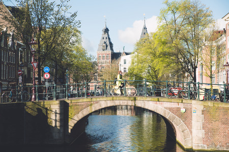 Amsterdam people riding bicycles in historical part in Amsterdam, Netherlands.のeditorial素材