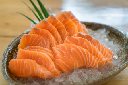 Raw salmon slice or salmon sashimi in Japanese style fresh serve on ice in bowl at Japanese restaurent.の写真素材