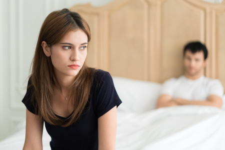 Unhappy couple not talking after an argument in bed at home. People, relationship difficulties and family conceptの写真素材