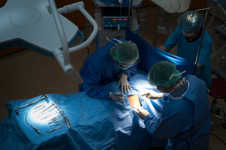 Asian doctor and an assistant in the operating room for surgical venous vascular surgery clinic in hospital.の写真素材