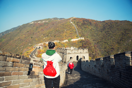 Young girl tourist from behind looking at view of Great Wall of China at famous Badaling tourism attraction during travel vacation in Beijing. Asia 
の写真素材