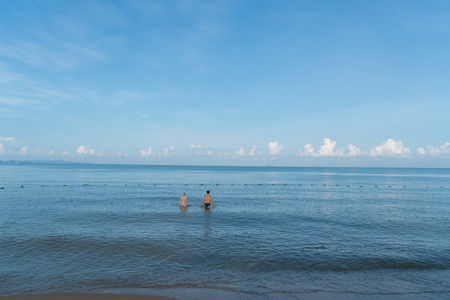 Back view of a romantic couple walking in sea during summer vacation at Phuket, Thailand.のeditorial素材