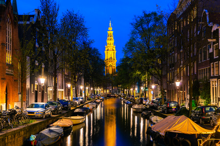 Amsterdam Zuiderkerk church tower at the end of a canal in the city of Amsterdam, Netherlands at night .の写真素材