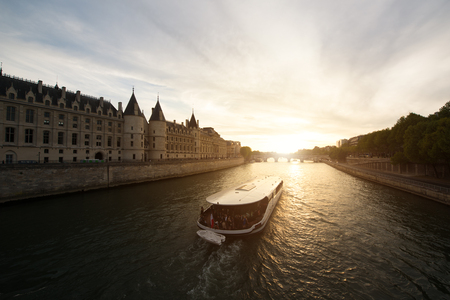 Tourist boat tour on Seine river with beautiful sunset in Paris . Cruise ship sightseeing along river in Paris, France.のeditorial素材