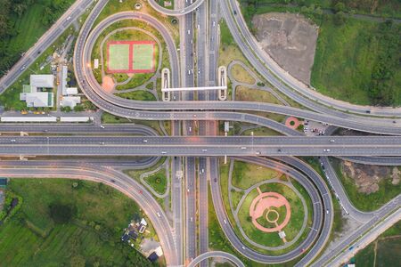 Aerial view of highway junctions Top view of Urban city, Bangkok at evening, Thailand. Car and truck...