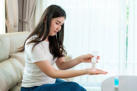 Asian woman using lotion or moisturize as hand of their daily life for protection skin to become dry and irritated after using alcohol antiseptic gel, prevention, cleaning hands infection, outbreak of Covid-19.の写真素材