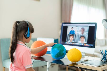 Asian girl student live learning video conference with teacher and other classmates giving...