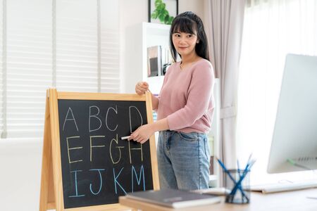 Asian woman teacher teaching English alphabet via video conference e-learning to elementary school student, Homeschooling and distance learning ,online ,education and internet.の写真素材