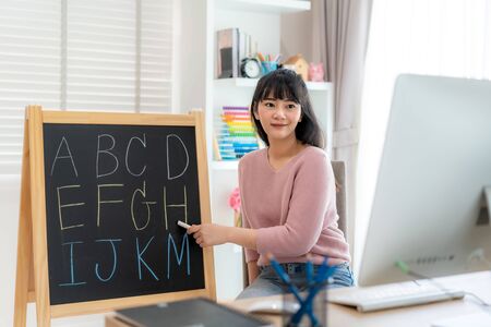 Asian woman teacher teaching English alphabet via video conference e-learning to elementary school student, Homeschooling and distance learning ,online ,education and internet.の写真素材