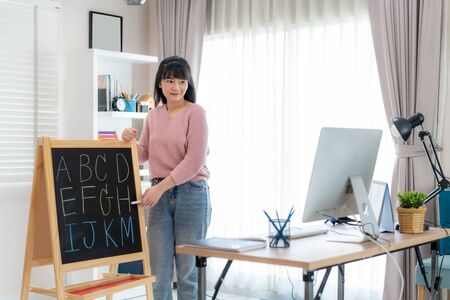 Asian woman teacher teaching English alphabet via video conference e-learning to elementary school student, Homeschooling and distance learning ,online ,education and internet.の写真素材