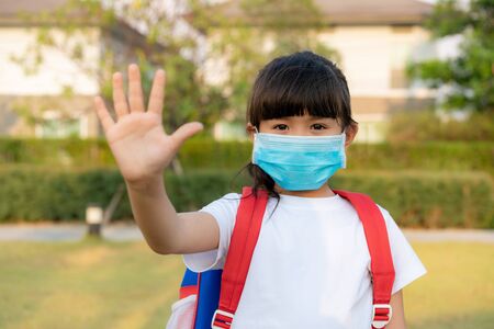 Little Asian girl wearing mask for protect pm2.5 and show stop hands gesture for stop corona virus outbreak. Covid-19 epidemic virus symptoms and Air pollution pm2.5 concept.の写真素材