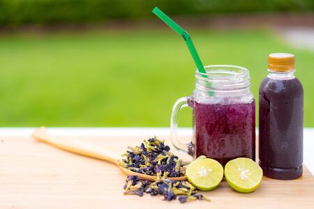 Butterfly pea flower herbal  and dry butterfly pea flower on wooden table Thai herb juice and refreshment cold drink.

の写真素材