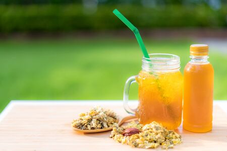 Cold water of chrysanthemum flowers and dried chrysanthemum flowers on wooden table chinese Thai herb juice and refreshment cold drink.の写真素材