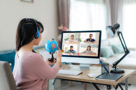 Asian woman teacher teaching geography via video conference e-learning and cheerful elementary school student looking at globe, Homeschooling and distance learning ,online ,education and internet.の写真素材