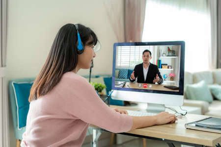 Businesswoman making video call to business partner using Computer. Close-up rear view of young woman having discussion with corporate client. Remote job interview, consultation, human resources conceptの写真素材