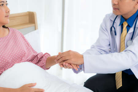 Close up of man doctor touching patient hand for encouragement and empathy on the hospital, cheering...