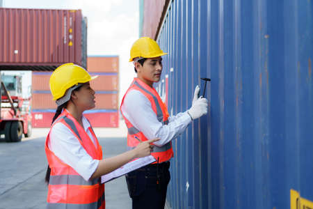 Asian engineer or Foreman using Chipping Hammer tool for checking the container after the repair complete to prepare the delivery to the customer.の写真素材