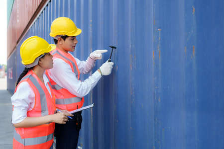 Asian engineer or Foreman using Chipping Hammer tool for checking the container after the repair complete to prepare the delivery to the customer.の写真素材
