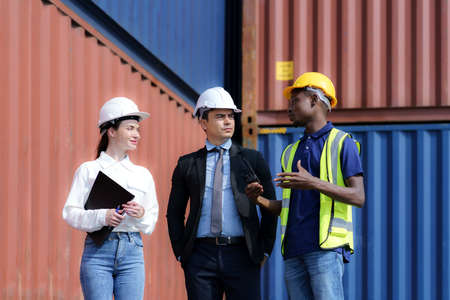 African american foreman is explaining the various sections of the container depot terminal to a caucasian man manager, with a female secretary next to him.の写真素材