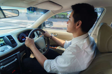 Asian man are driving on city streets to get to work in the morning.の写真素材