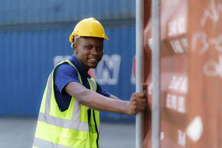 African-American black workers are opening containers for inspection and check that repairs have...