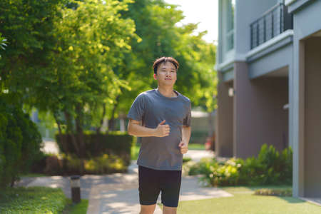 Asian man are jogging in the neighborhood for daily health and well being, both physical and mental and simple antidote to daily stresses and to socialize safely.の写真素材
