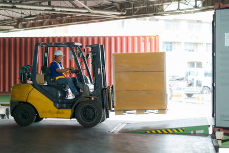 Forklift are loading into cargo containers at warehouses, ports, freight forwarding, cargo supply chains, cargo transportation, warehouse industry, logistics.の写真素材