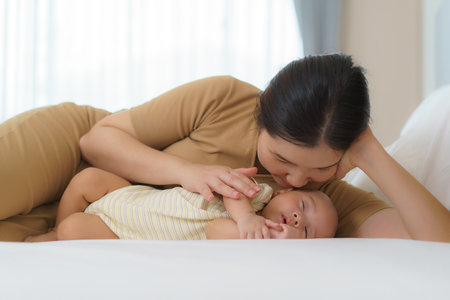 The Asian mother hugged her young son so that she could have a good sleep in the bedroom at home, Represents love and familyの写真素材
