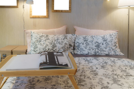 Cozy bedroom adorned with a soft lamp, casting a warm and inviting glow. This scene embodies a serene retreat, perfect for winding down and embracing the comfort of a well-lit, intimate spaceの写真素材