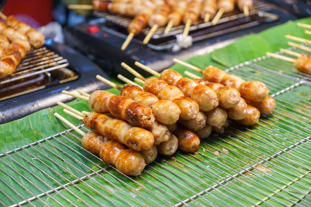 Embark on a culinary journey through Thailand's Isan region with this savory treat! Hanging proudly at a bustling hawker stall, these traditional pork and rice sausages, also known as fermented hot dogs, entice with their rich aroma and authentic northeastern Thai flavors. Experience a taste of traditionの写真素材