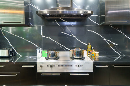 Interior shot of a modern kitchen. Featuring a sleek stove, a stylish sink, and a sophisticated exhaust hood, this space embodies the perfect fusion of functional design and contemporary eleganceの写真素材