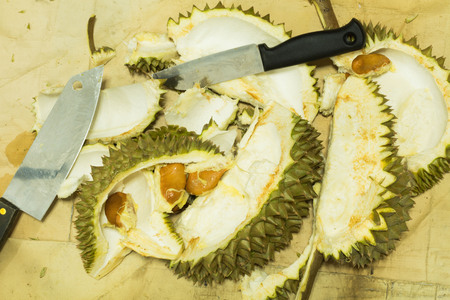 Knife is Peeling the King of Fruit in Thailand also know as Durian Peel on Brown Paper and Backgroundの写真素材