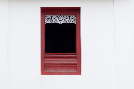 Open brown wooden window on white wall at Wat Phra That Kao Noi, Nan Thailand.