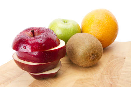 round shape fruit, red and green apple, orange, kiwi on wood plate.の写真素材