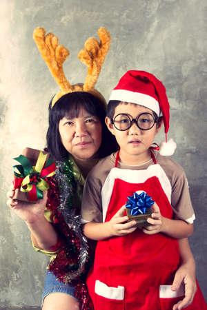 Christmas family, A Santa boy and Reindeer auntie hug and holding gift boxes.の写真素材