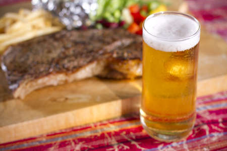 football meal, set of beef steak and beer on the tableの写真素材