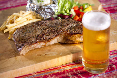 football time, set of beef steak and beer on the tableの写真素材