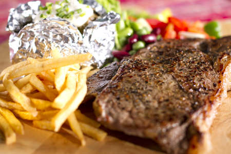 sirloin steak meal, sirloin steak meal on dish with fries baked potato and salad.の写真素材