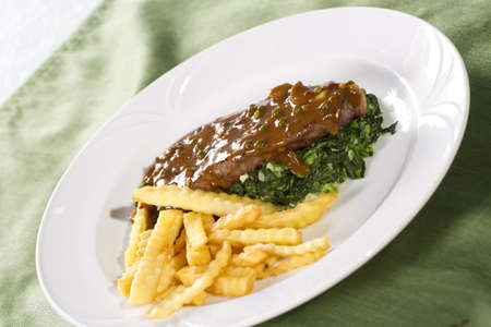 steak, beef steak with brown sauce spinach and french friesの写真素材