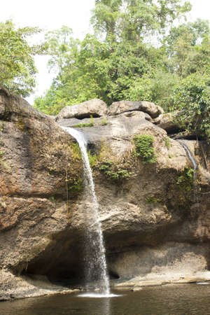 waterfall, water flowing down to wide stream in the green forest の写真素材