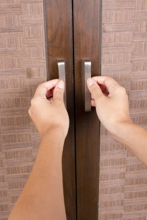 to open closet door, female hands opening closet doorの写真素材